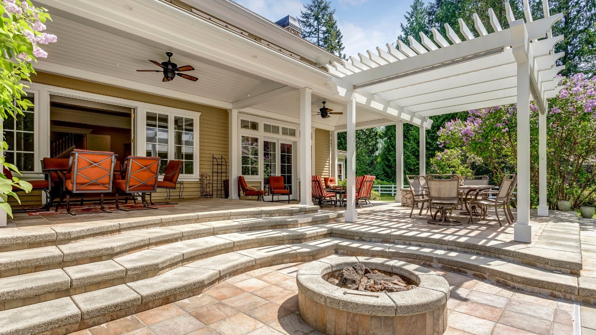 Luxurious outdoor patio with fire pit, pergola, and comfortable seating areas