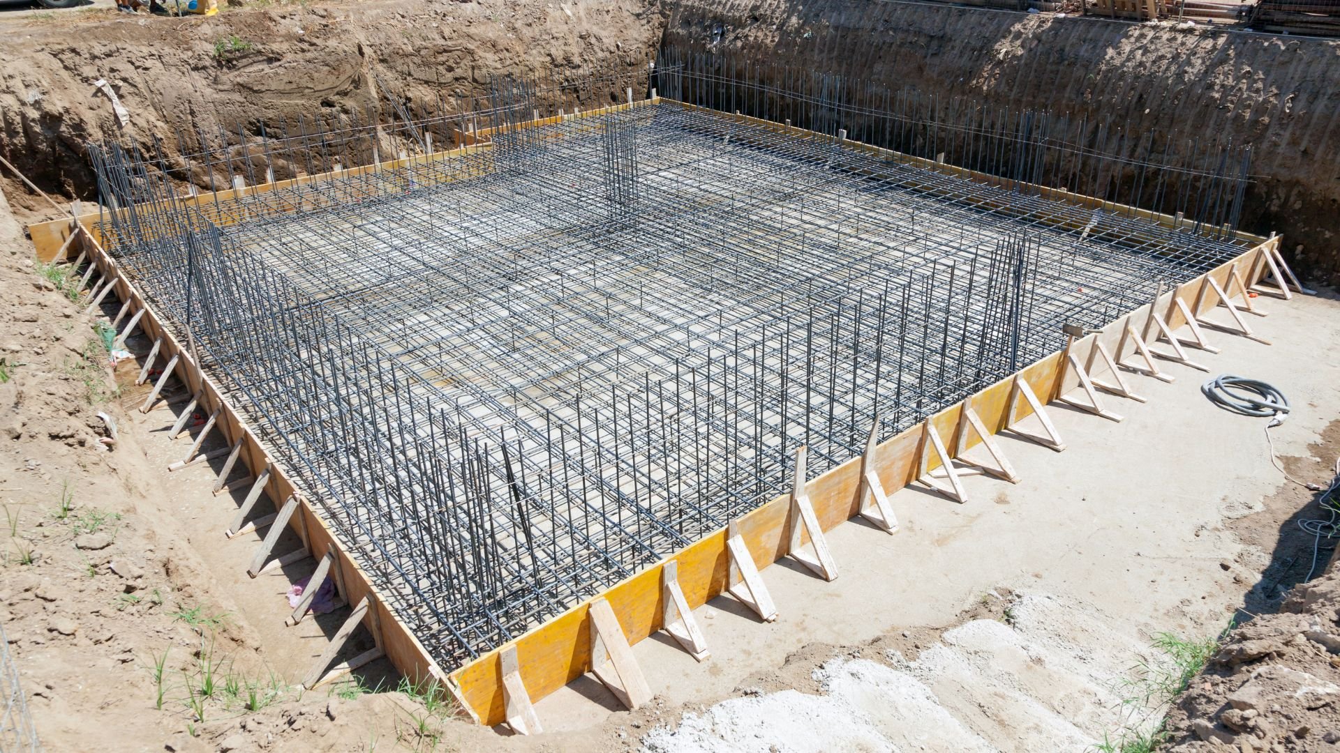 Construction site with reinforced steel rebar grid prepared for concrete foundation