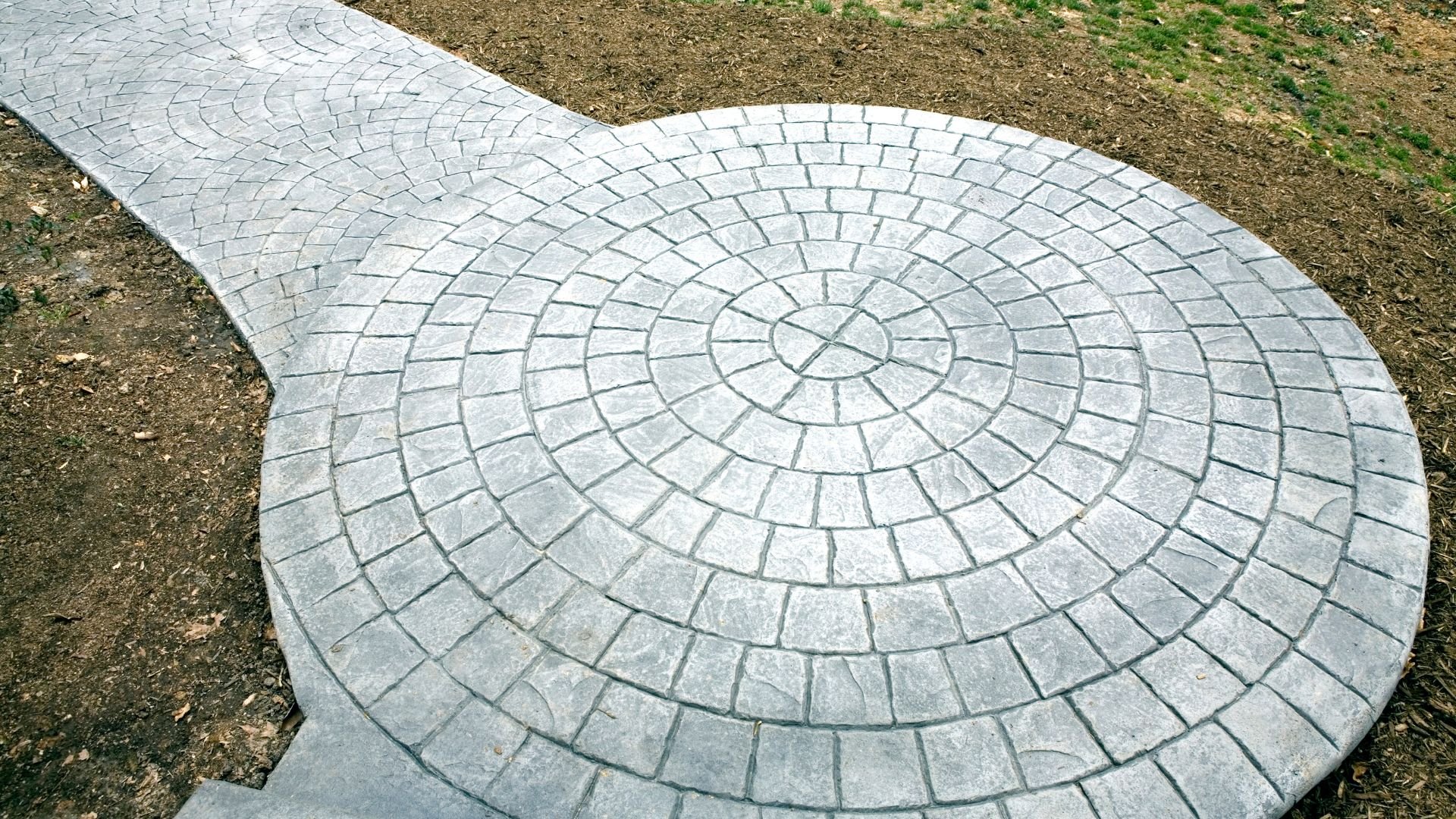 Circular stone patio with radial pattern of interlocking pavers