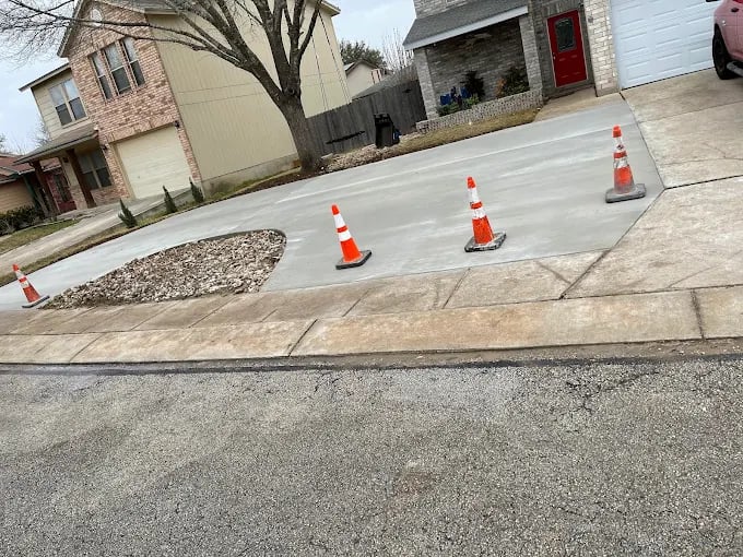 Orange traffic cones marking a section of residential concrete driveway