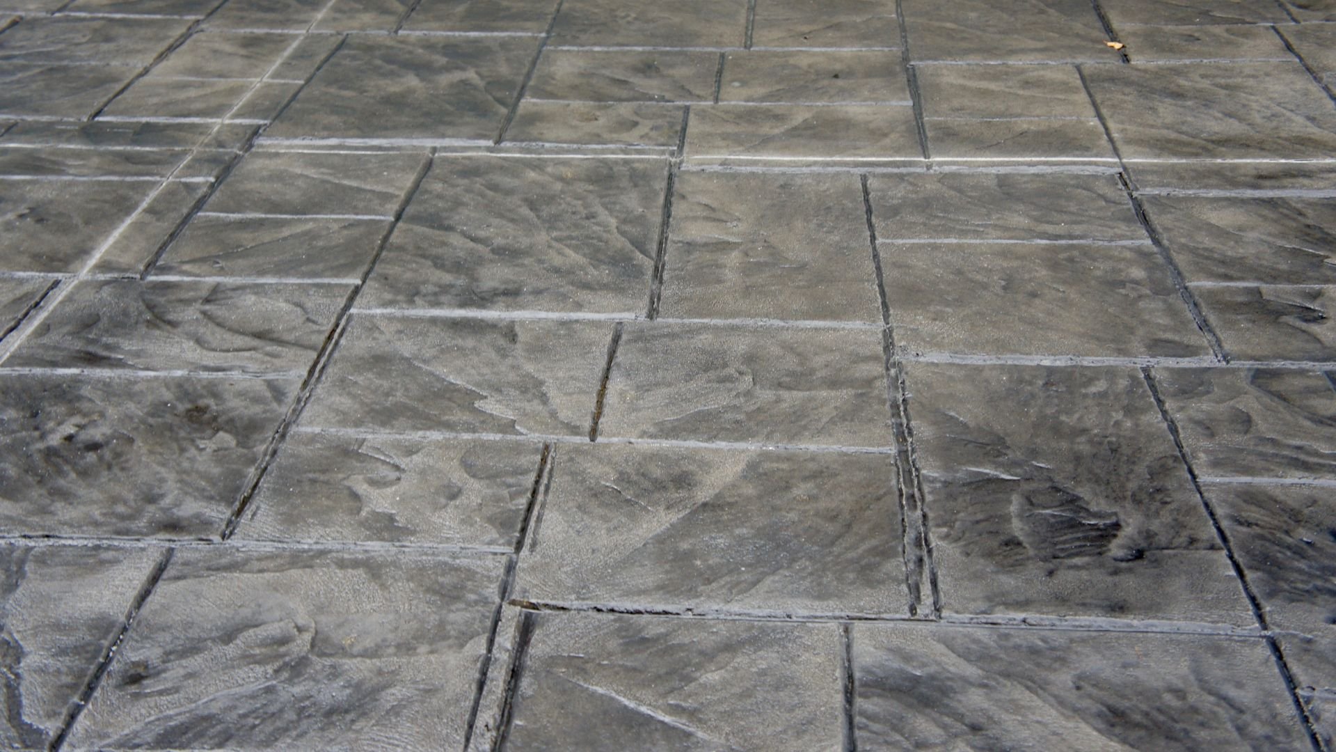Stamped concrete patio with textured stone-like pattern in gray tones